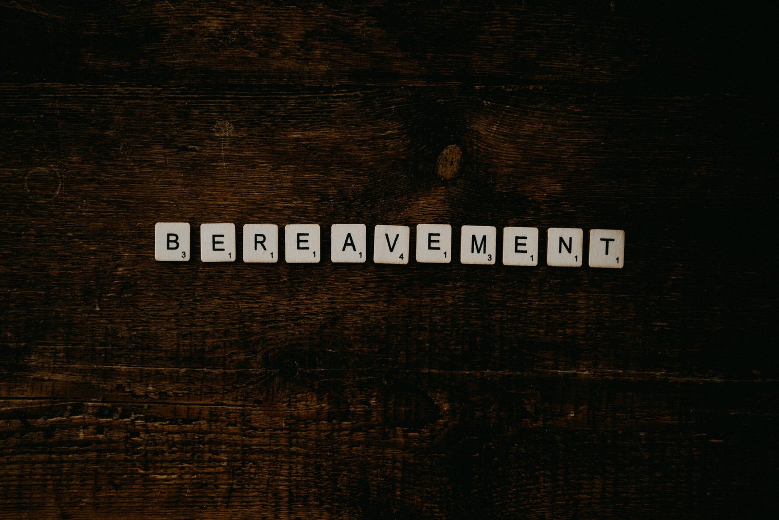 the word bereavement spelled with cubes on a wooden surface